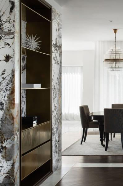 Modern dining room with decorative shelving, marble wall detail and soft natural light